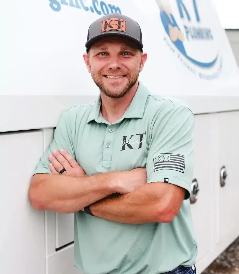 tech smiling in front of truck with arms crossed