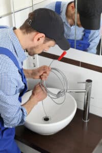 plumber in greer snaking a bathroom sink